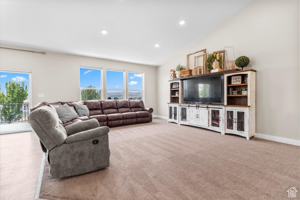 Living room with plenty of natural light, recessed lighting, and lofted ceiling