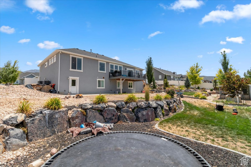 Back of house featuring stucco siding and a lawn