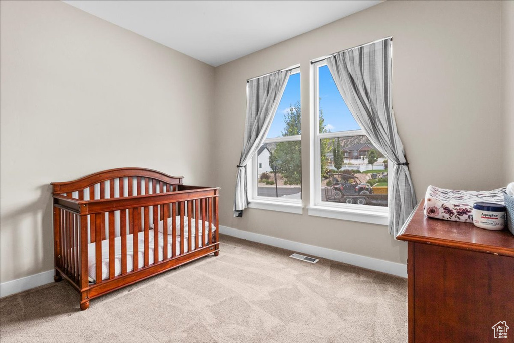 Bedroom featuring carpet floors and a nursery area