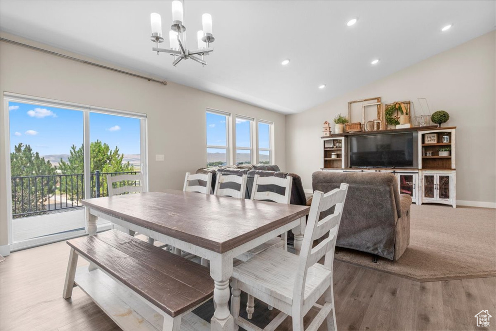 Dining area with a chandelier, light wood finished floors, recessed lighting, and lofted ceiling