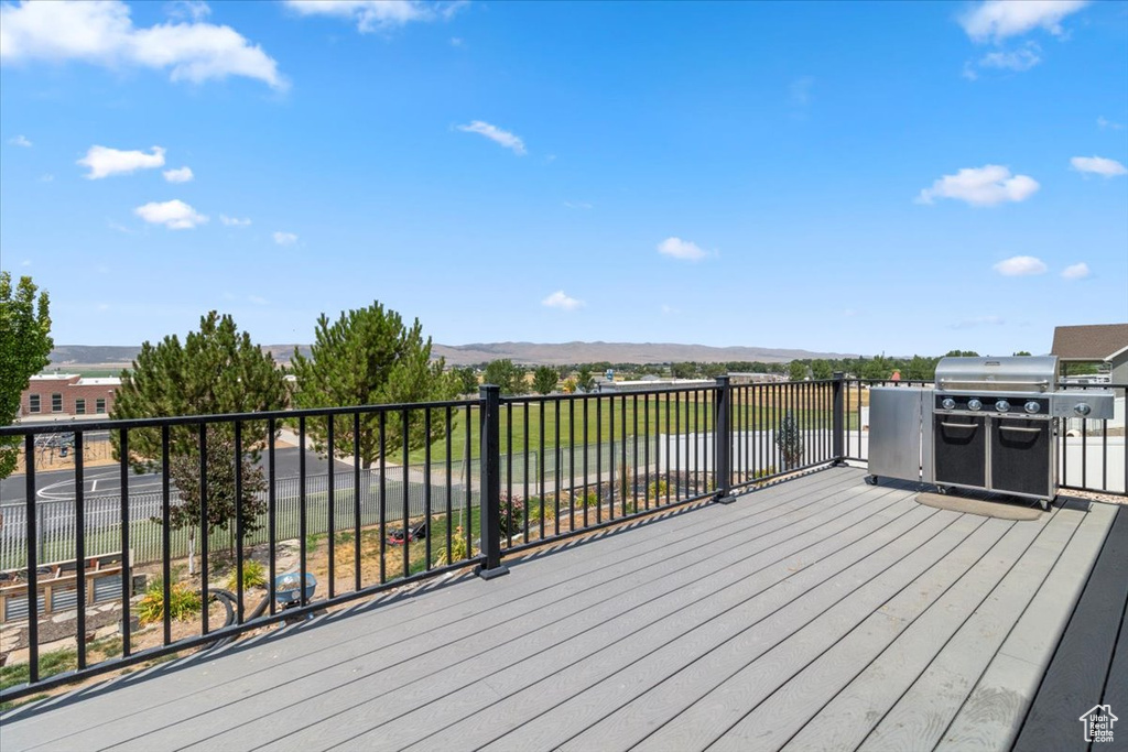 Deck with a water view and area for grilling