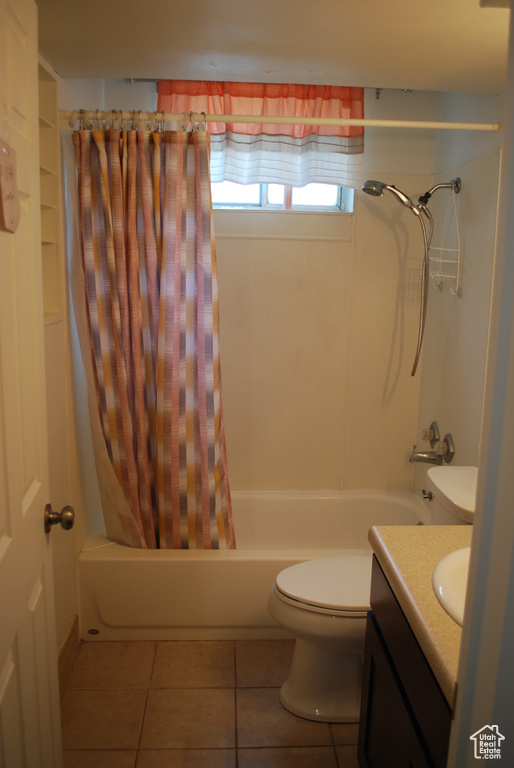 Full bath with shower / bathtub combination with curtain, vanity, and tile patterned floors