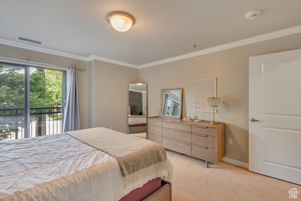 Bedroom with crown molding, light colored carpet, and access to exterior