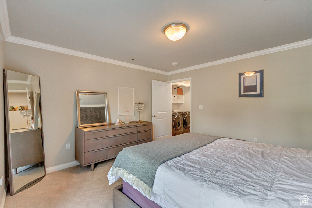 Bedroom with washing machine and clothes dryer, ornamental molding, and light colored carpet