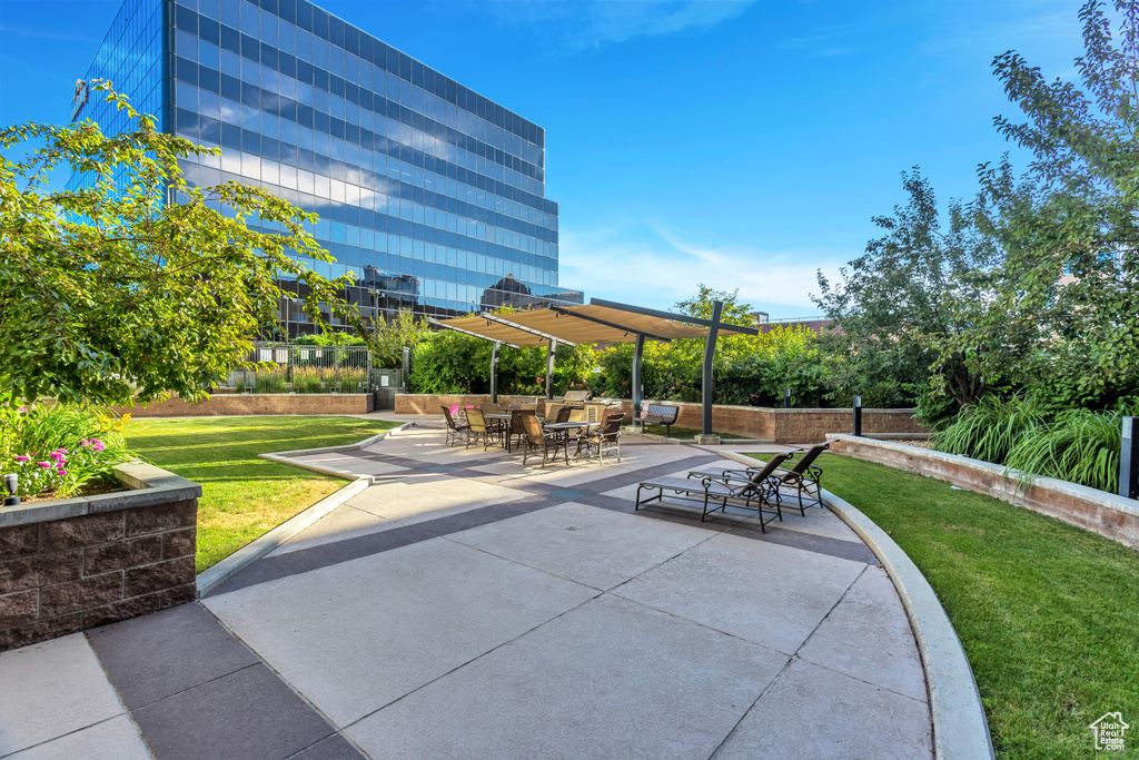 View of community with a patio, a yard, and outdoor dining space
