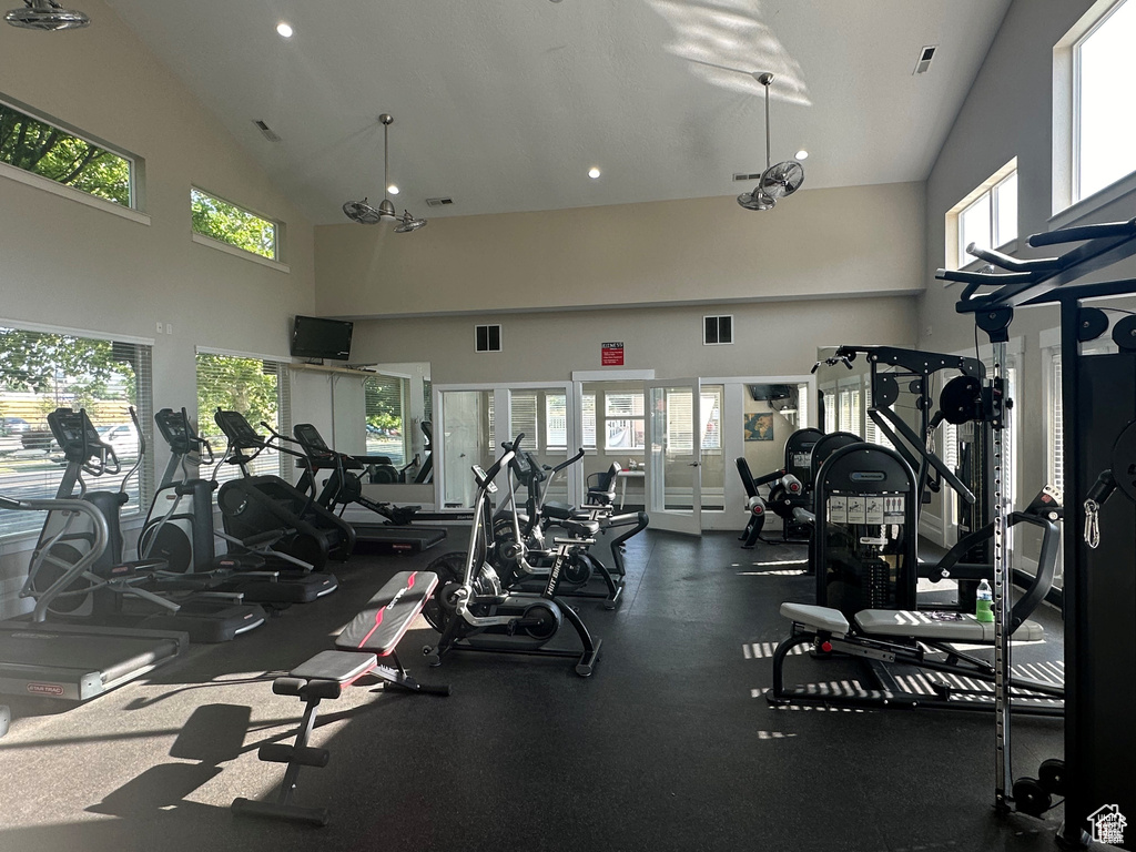 Workout area with high vaulted ceiling, plenty of natural light, and recessed lighting