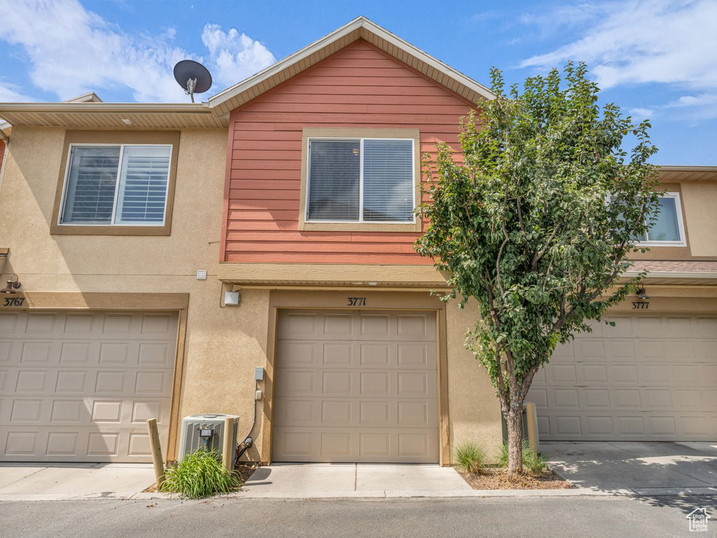 Traditional home featuring stucco siding and an attached garage