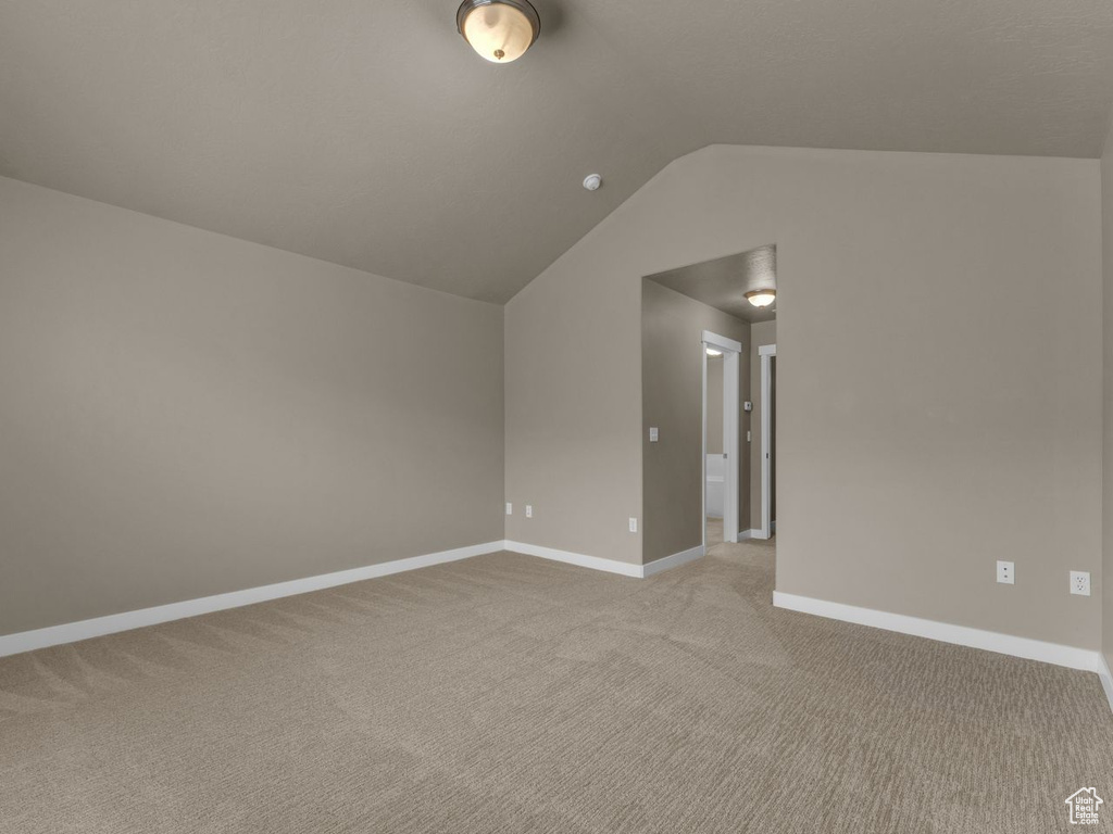 Bonus room with light carpet and lofted ceiling