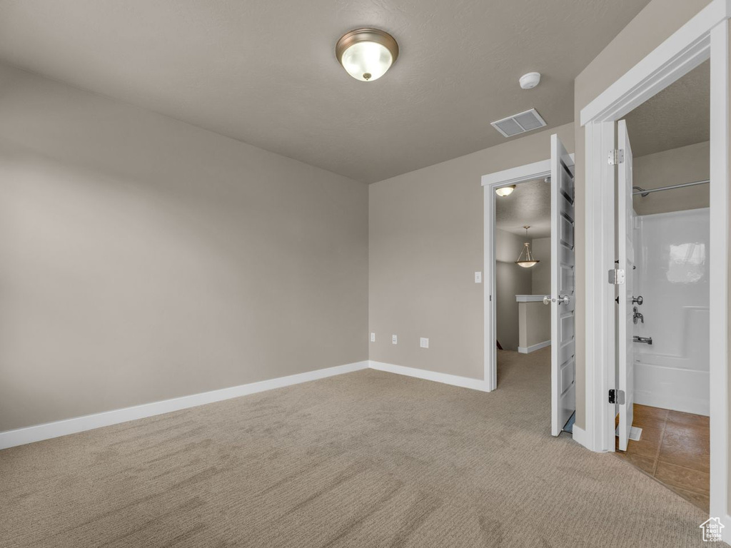Unfurnished bedroom featuring carpet floors and a walk in closet