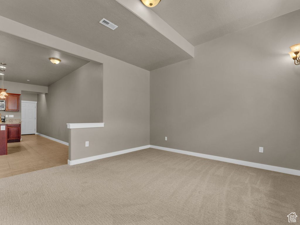 Unfurnished living room with baseboards and light carpet