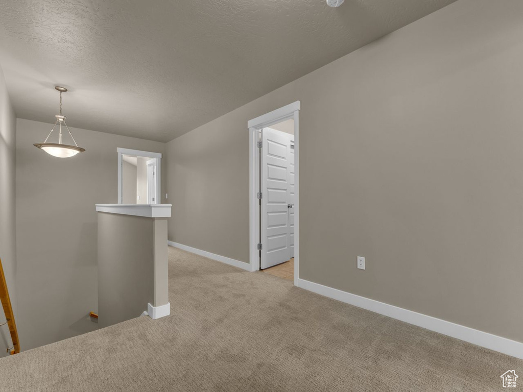 Spare room with light colored carpet and a textured ceiling