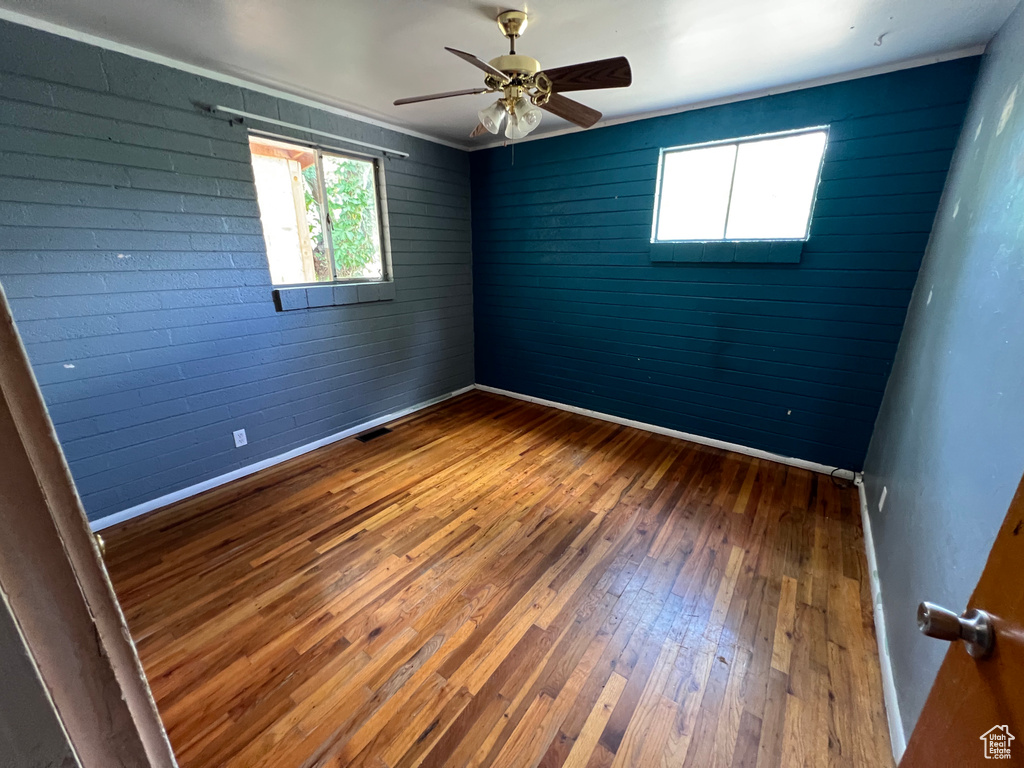 Empty room with wood-type flooring and a ceiling fan