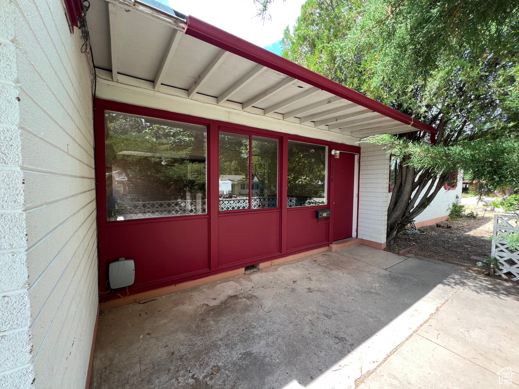 Property entrance featuring brick siding and a patio