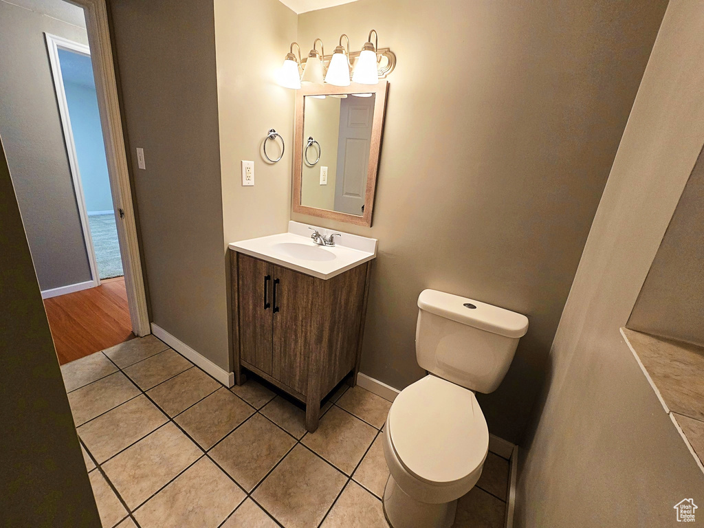 Half bathroom with vanity and tile patterned floors