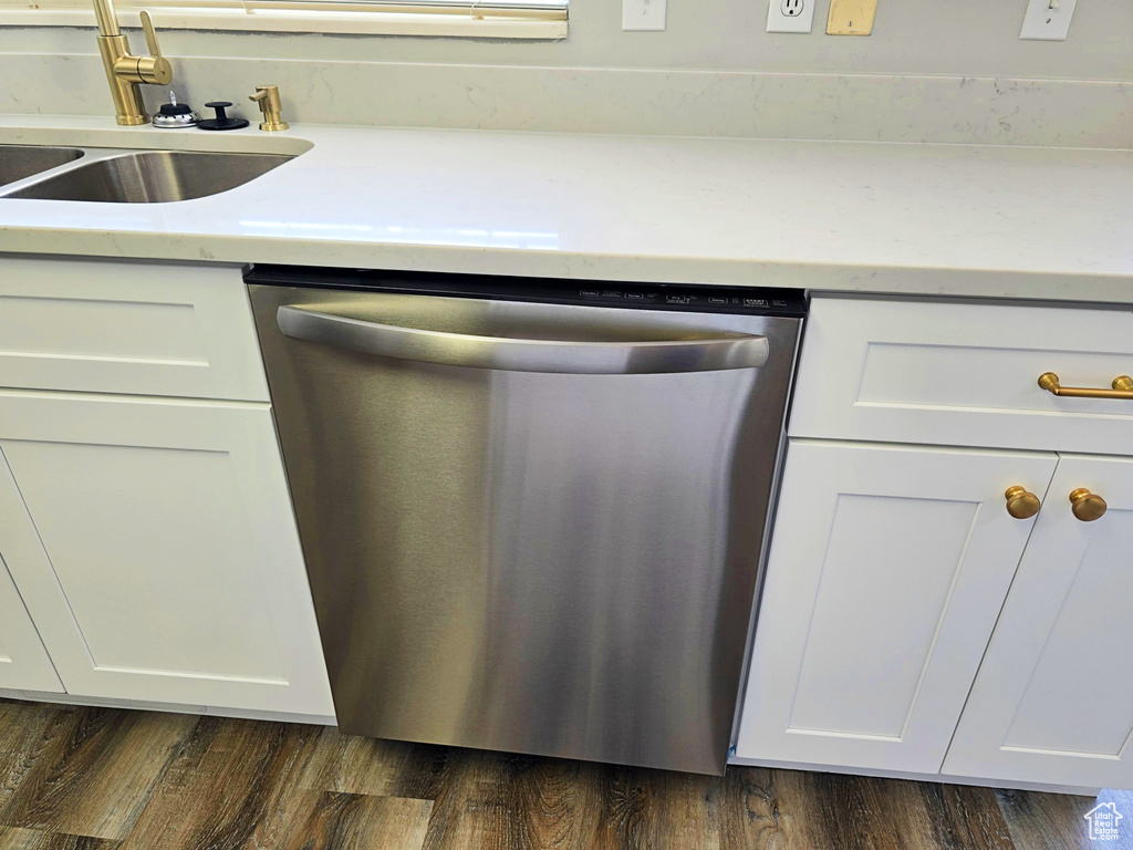 Kitchen featuring stainless steel dishwasher, white cabinets, and dark wood-style floors