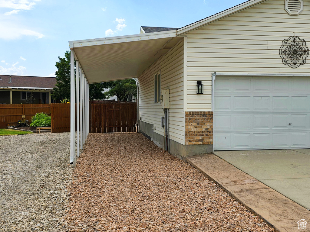 View of side of property with driveway and brick siding