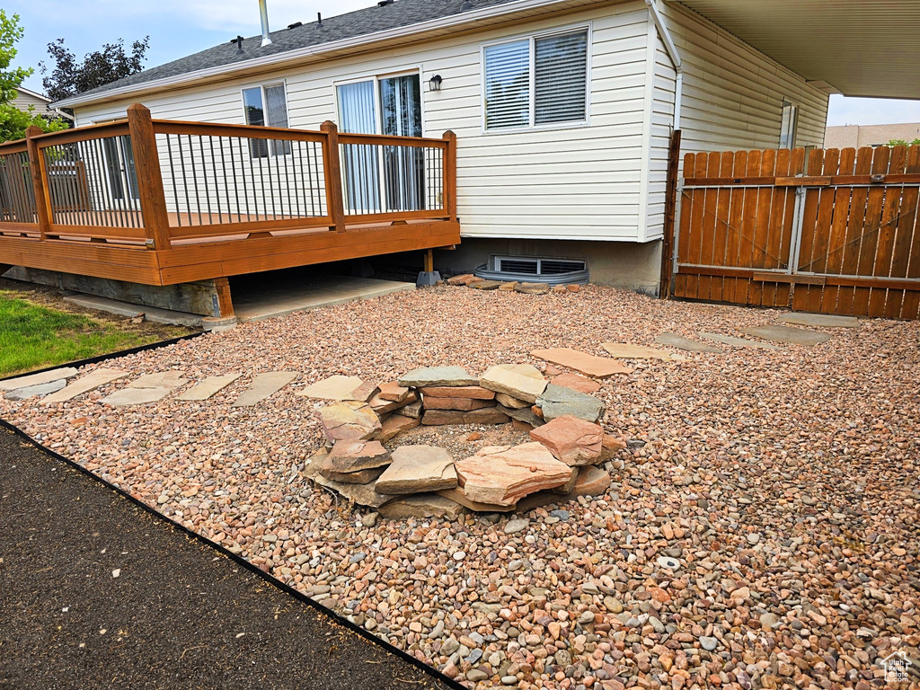 Back of property featuring a wooden deck and a shingled roof