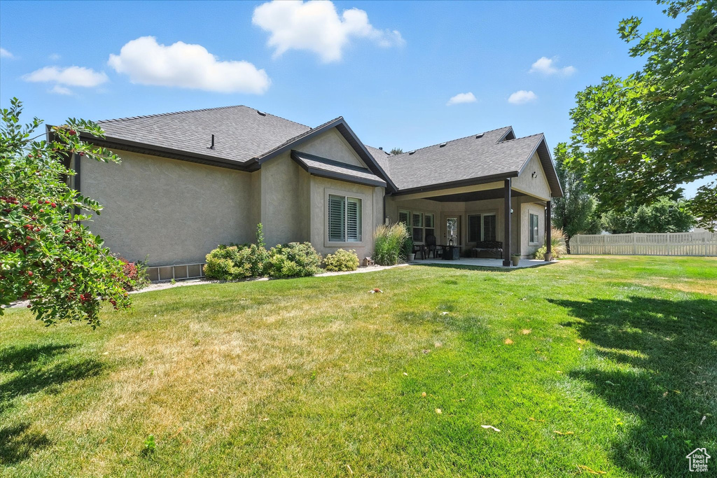 Back of house featuring stucco siding, a patio area, and a shingled roof