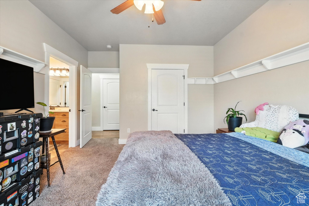 Carpeted bedroom with ceiling fan and ensuite bathroom