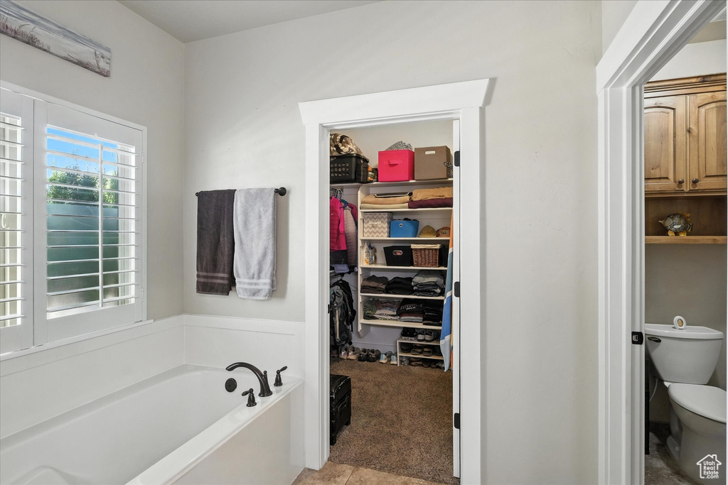 Bathroom featuring a bath and a spacious closet
