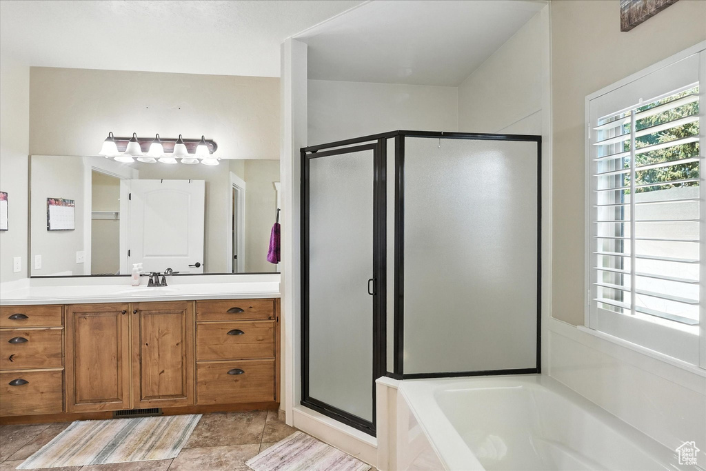 Bathroom featuring a stall shower, vanity, and a bath