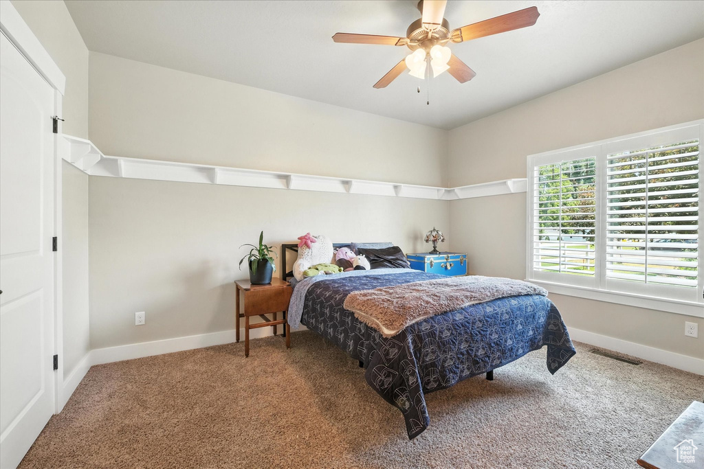 Carpeted bedroom featuring baseboards and a ceiling fan