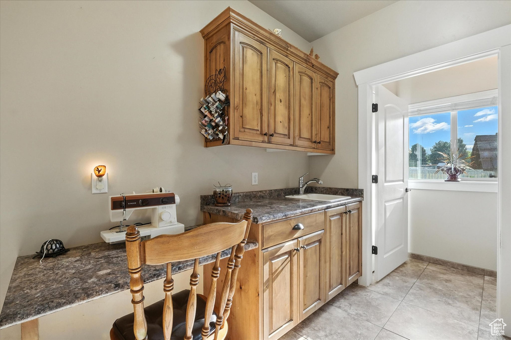 Kitchen featuring light tile patterned floors and brown cabinetry