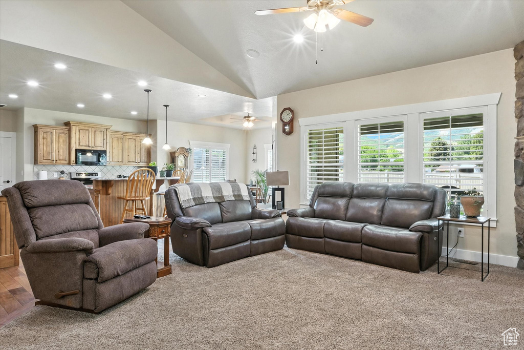 Living room with ceiling fan, recessed lighting, vaulted ceiling, and light colored carpet
