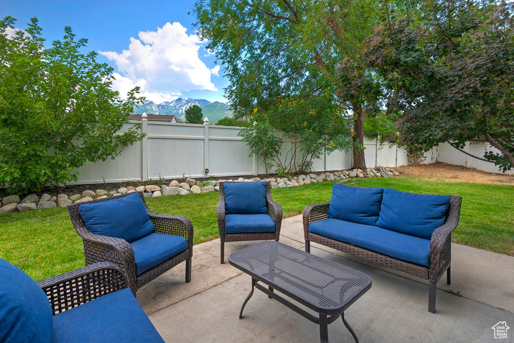Fenced backyard featuring a patio area, a mountain view, and an outdoor hangout area