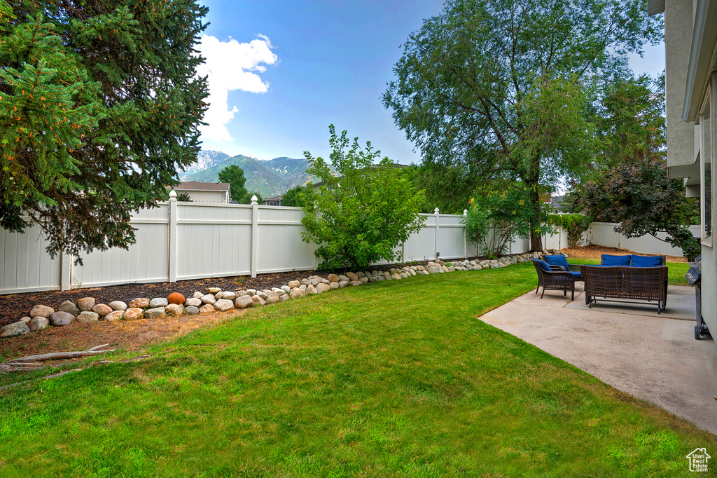 Fenced backyard featuring a mountain view and a patio