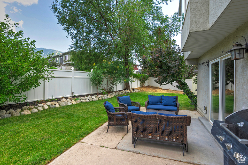 Fenced backyard with an outdoor living space, a patio area, and area for grilling