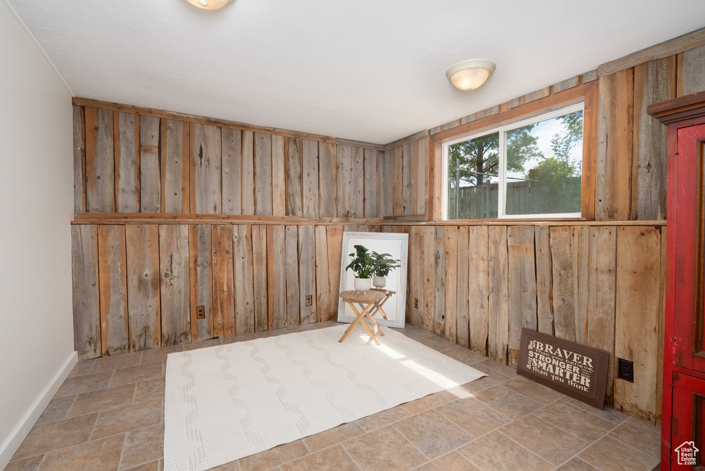 Spare room with wood walls and stone finish flooring