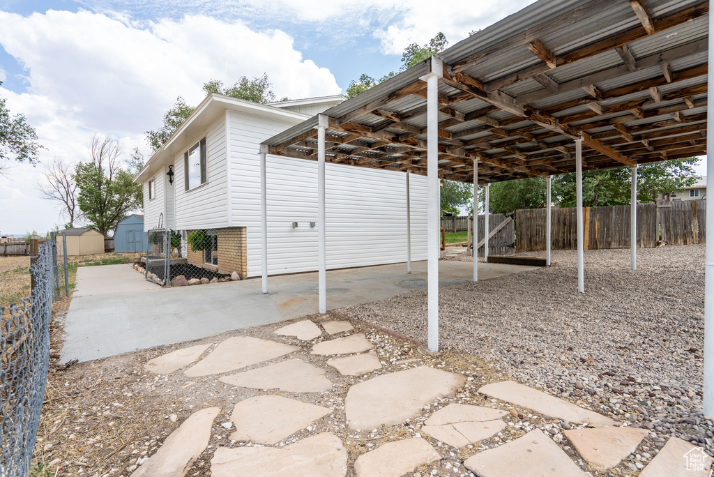 View of patio with a carport and a shed