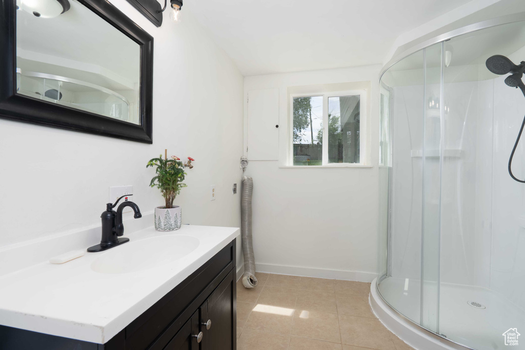 Full bath featuring vanity, a stall shower, and tile patterned floors