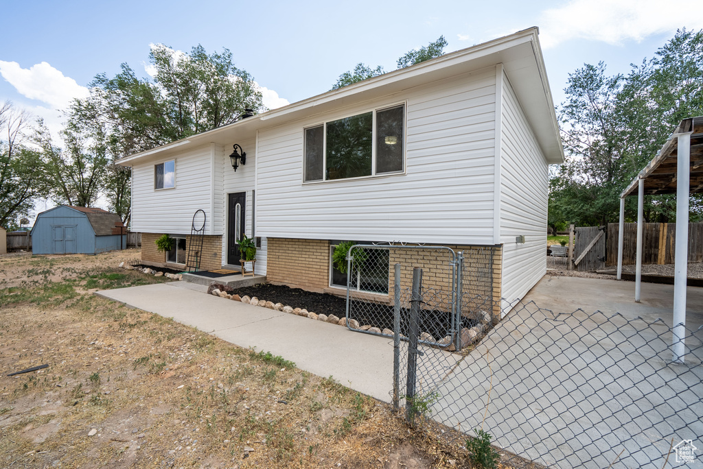 Split foyer home featuring a storage unit and a patio