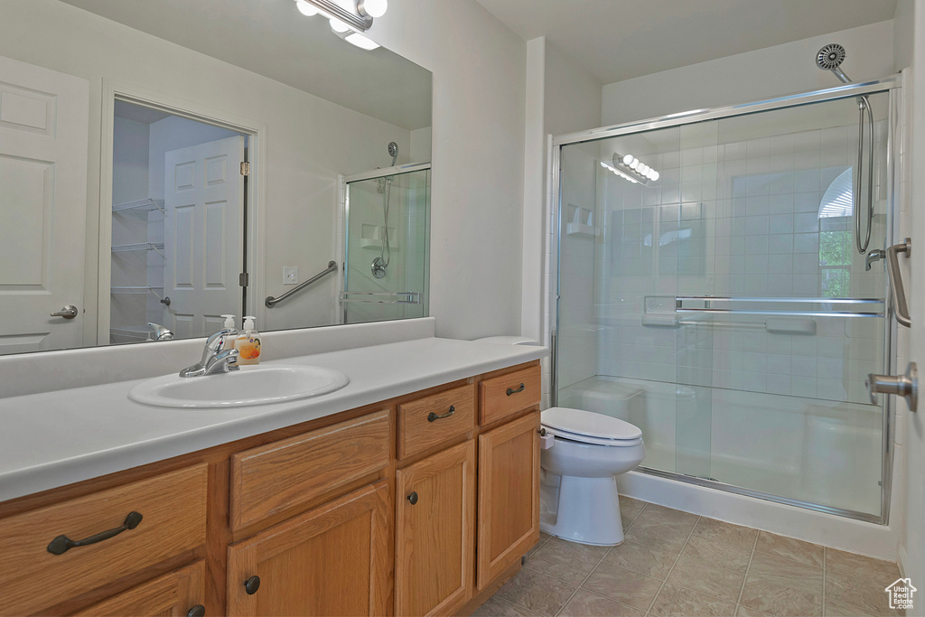 Bathroom featuring vanity, a stall shower, and tile patterned floors