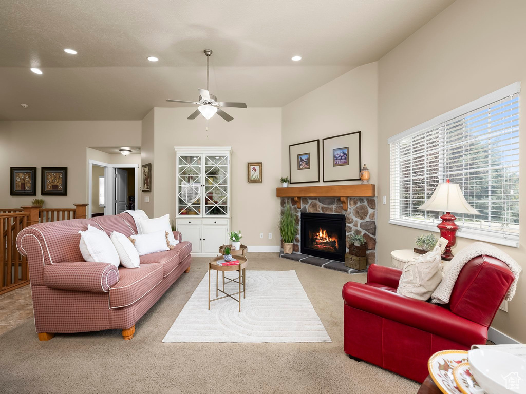 Carpeted living area with ceiling fan, a stone fireplace, recessed lighting, and high vaulted ceiling