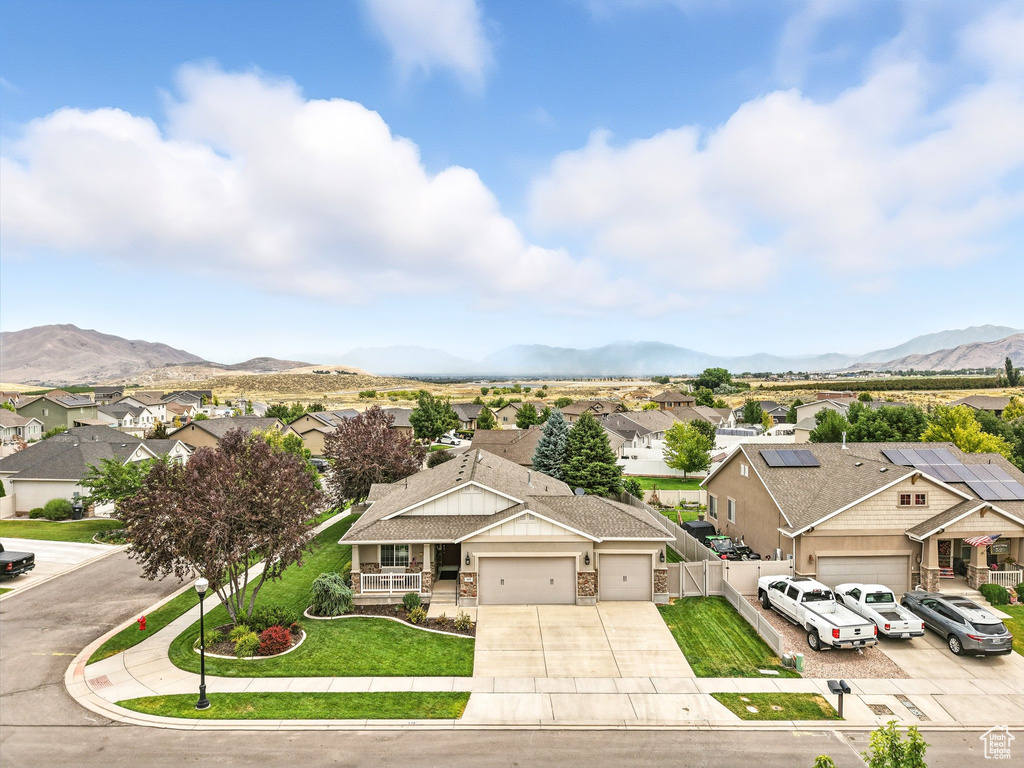 View of front of house with a residential view, driveway, an attached garage, and a shingled roof