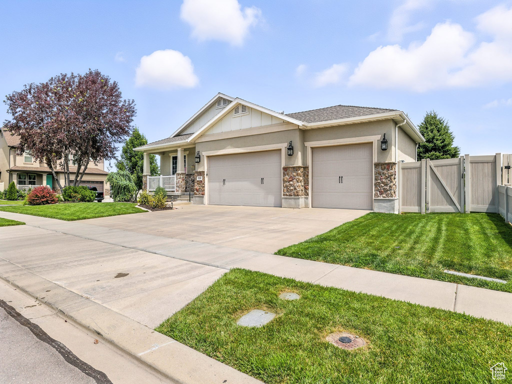 Craftsman house with a gate, a garage, concrete driveway, stone siding, and stucco siding