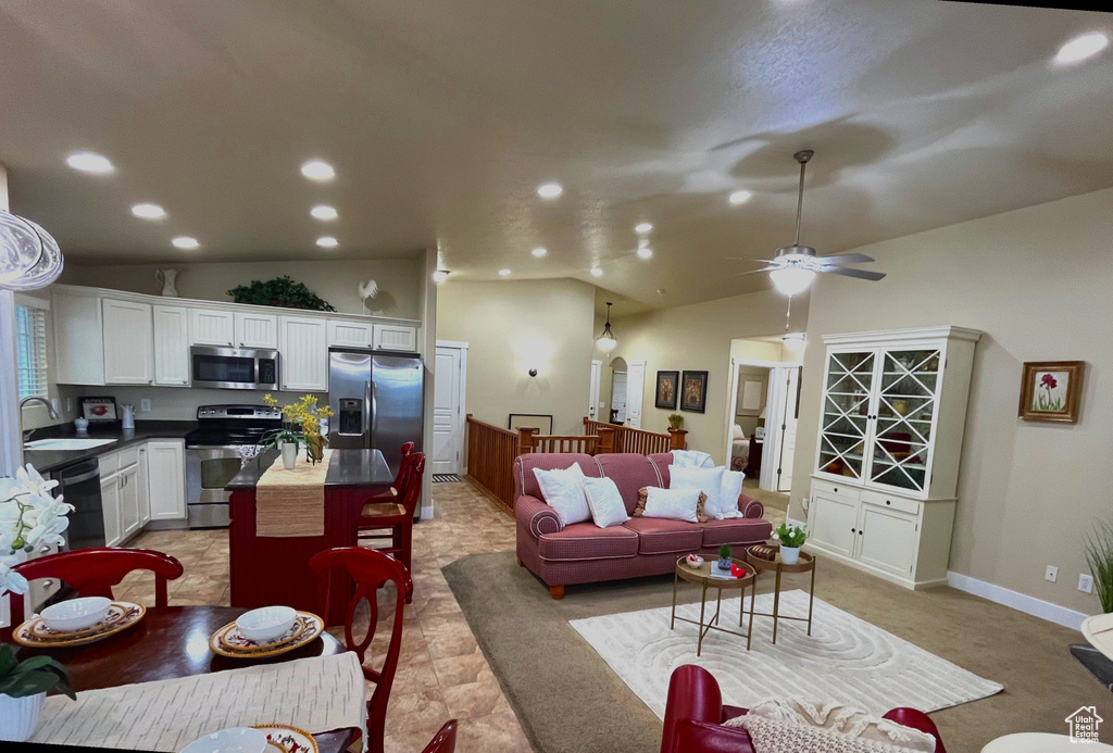 Living area with lofted ceiling, ceiling fan, and recessed lighting
