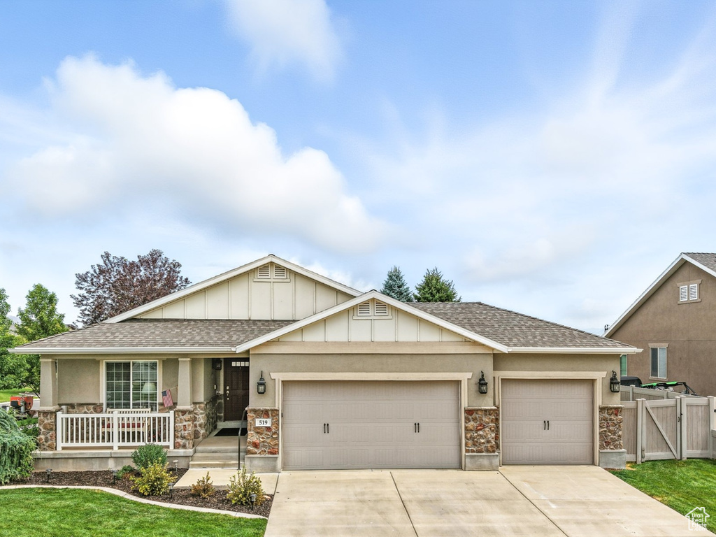 Craftsman-style home featuring a garage, a porch, concrete driveway, board and batten siding, and roof with shingles