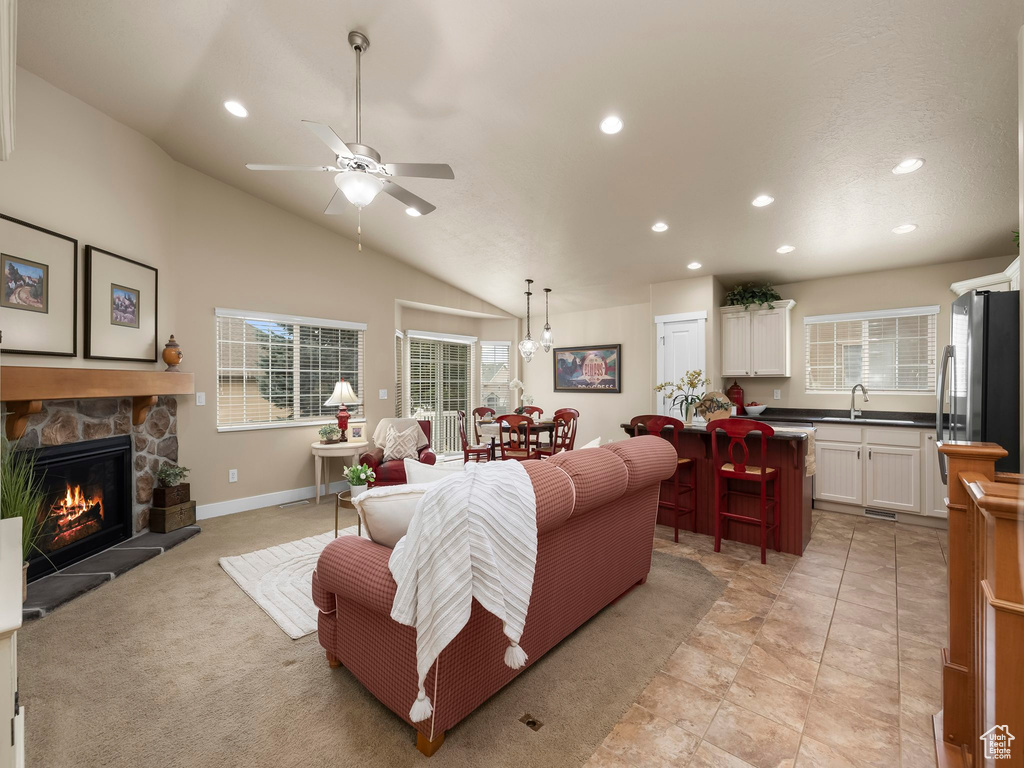 Living area with a fireplace, recessed lighting, a ceiling fan, and vaulted ceiling