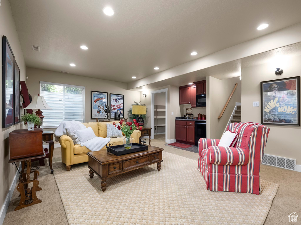 Living room with light colored carpet, recessed lighting, and stairway