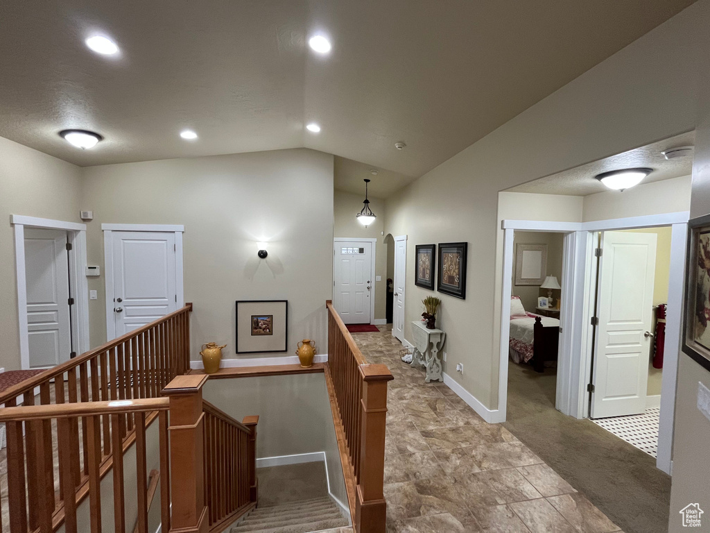 Staircase with lofted ceiling, recessed lighting, and carpet flooring