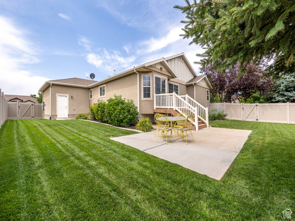Back of house featuring a gate, a patio, a fenced backyard, and stucco siding