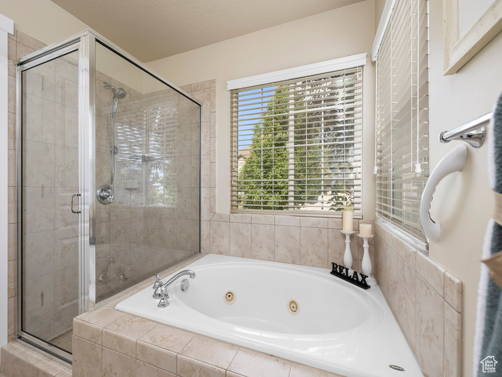Full bathroom featuring a whirlpool tub and a stall shower