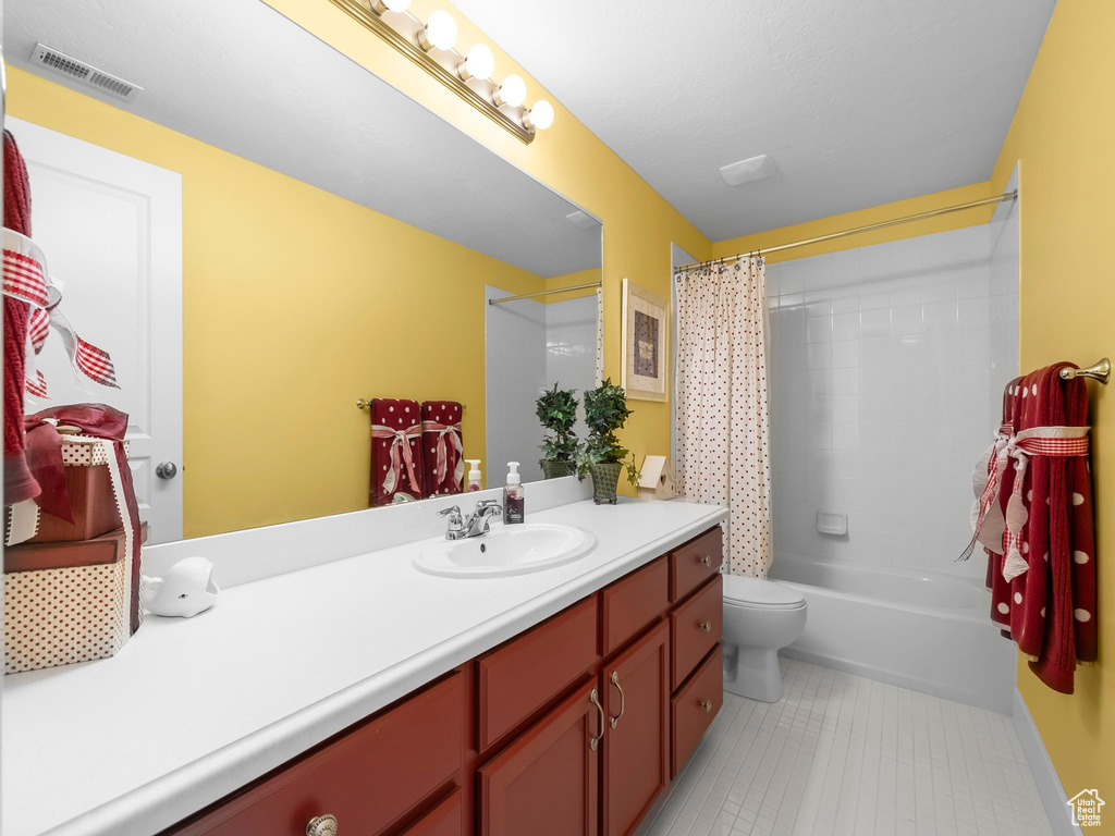Bathroom with vanity, tile patterned floors, and shower / bath combination with curtain