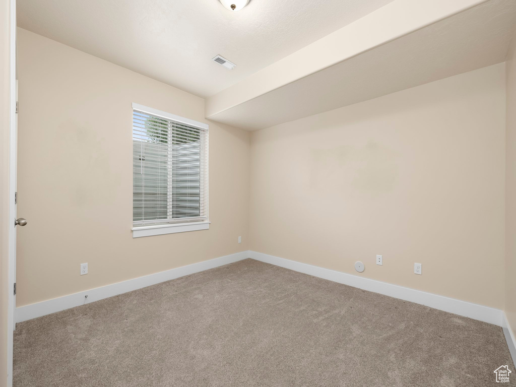 Carpeted empty room featuring baseboards