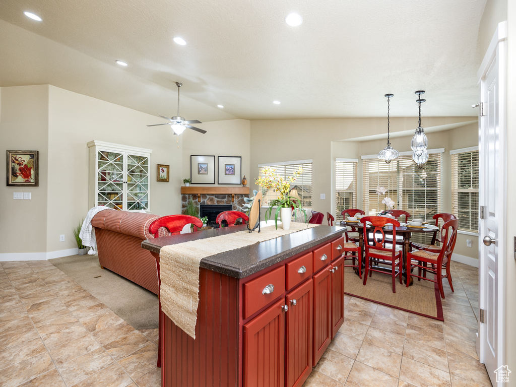 Kitchen with reddish brown cabinets, a fireplace, recessed lighting, a ceiling fan, and open floor plan