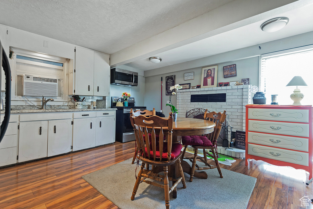 Dining area featuring dark wood-type flooring and a textured ceiling